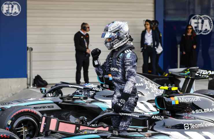 Andrea Kimi Antonelli col casco accanto alla sua Mercedes in pit-lane.