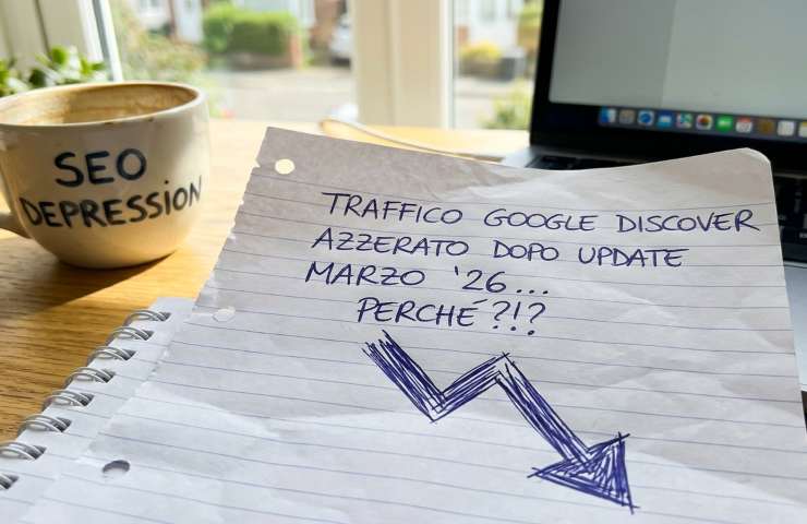 Appunti scritti a mano su un grafico in calo dopo l'aggiornamento Google Discover di Marzo 2026, con una tazza di caffè su una scrivania illuminata dal sole.