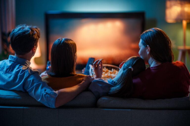 famigli seduta sul divano che guarda la tv